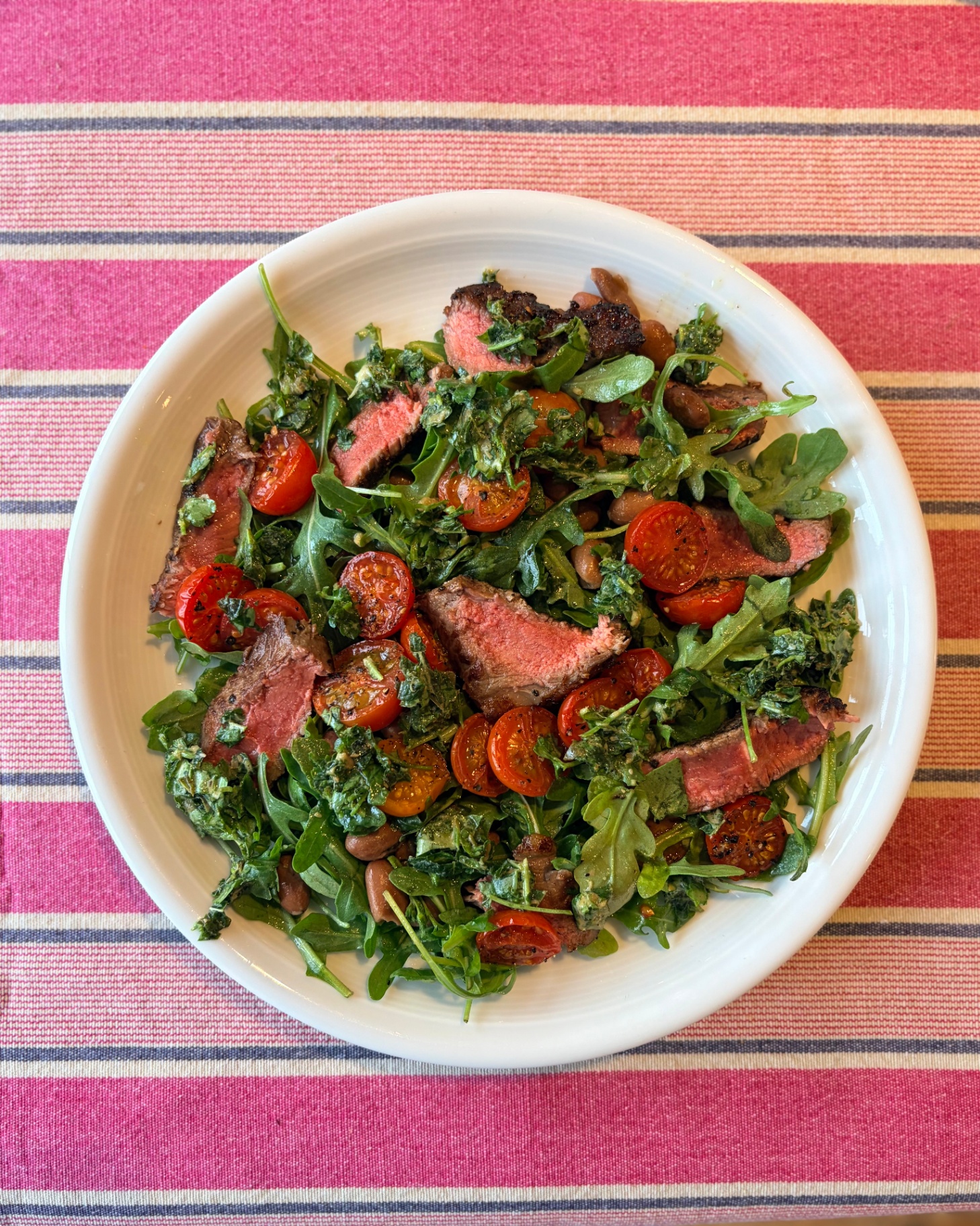 Griddled steak with roasted tomatoes, wilted rocket and salsa verde